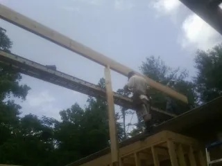 Carpenter setting a ridge beam over a new addition frame — Ice Dam Removal by Roofing Brothers in Monona