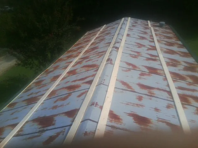 Rusted metal roof panels with new wood purlins before replacement — Storm Damage Roof Repair in Monona by Roofing Brothers