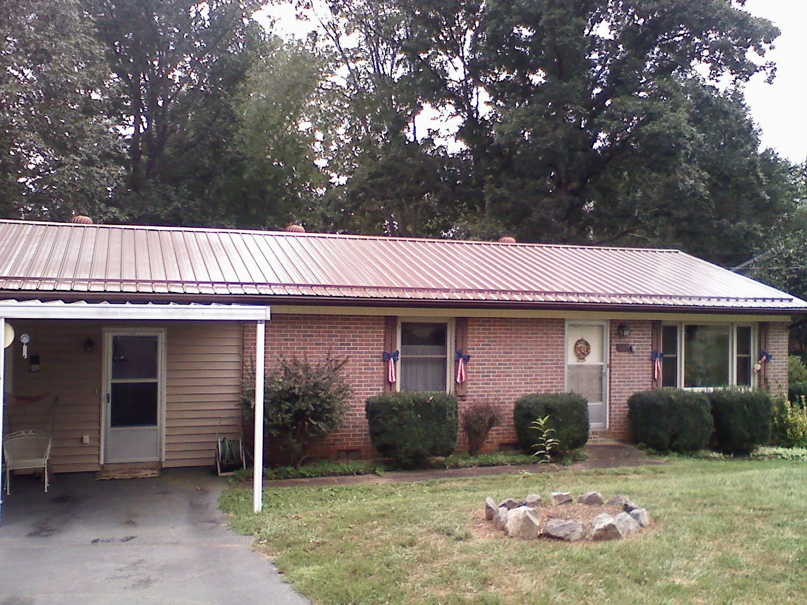 Bronze metal roof and carport on a brick ranch home — Roof Repair work by our crew in Monona