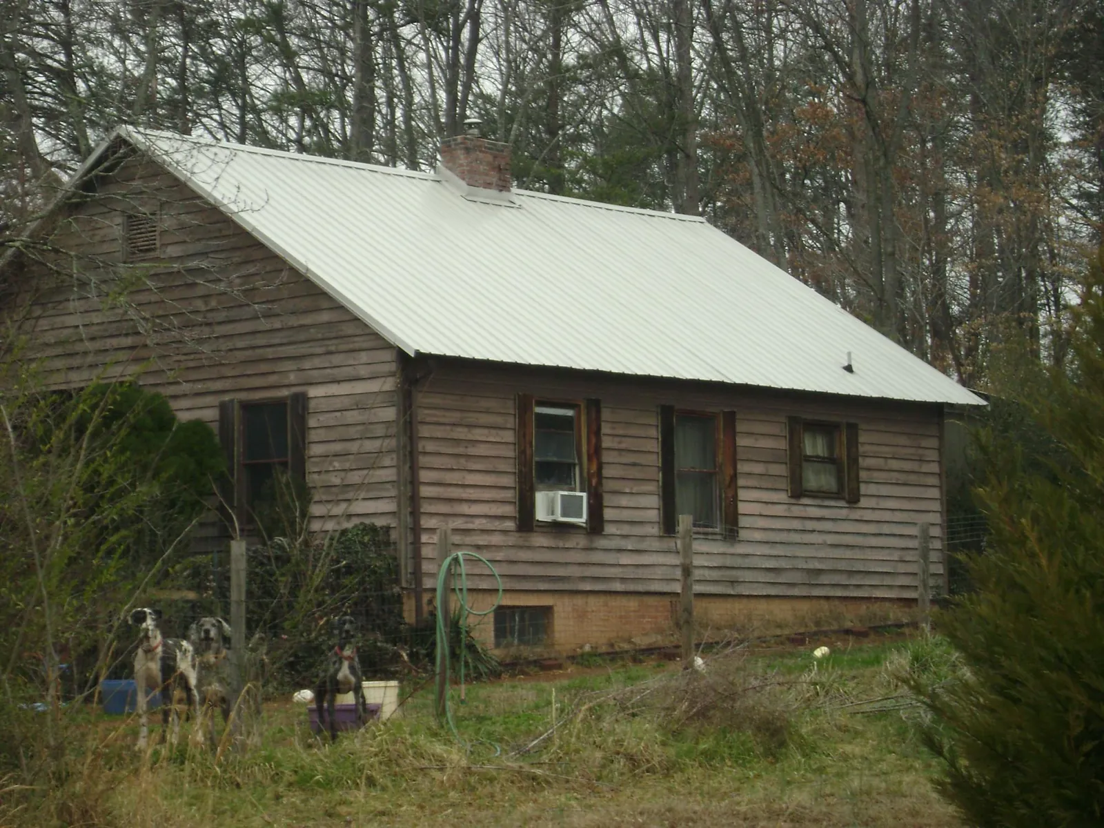 White metal roof on an old wood sided farmhouse, from a Metal Roof Installation job in Monona